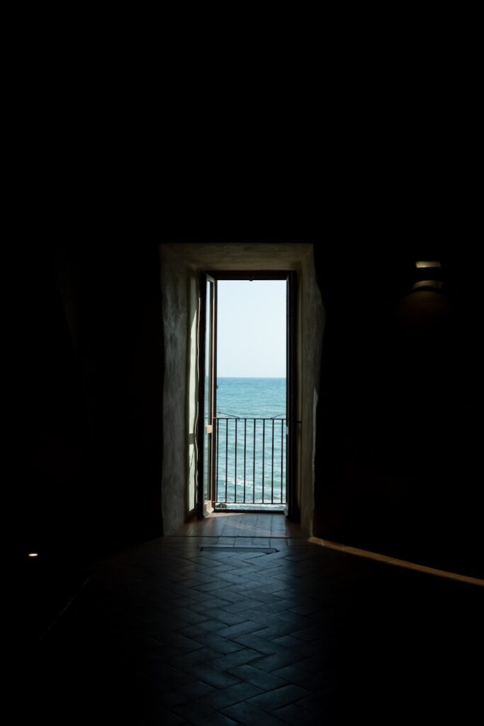 Photo by Matteo Basile Open Door with a Sea View in a Hallway